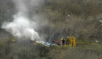 FILE - Firefighters work the scene of a helicopter crash where former NBA basketball star Kobe Bryant died in Calabasas, Calif., Jan. 26, 2020. Bryant&#39;s widow is taking her lawsuit against the Los Angeles County Sheriff&#39;s Department and Fire Department to a federal jury seeking compensation for photos deputies shared of the remains of the NBA star, his daughter and seven others killed in a helicopter crash in 2020. (AP Photo/Mark J. Terrill, File)