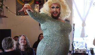 This July 28, 2022, photo shows emcee Golden Delicious performing before a mock election at Cafecito Bonito in Anchorage, Alaska, where people ranked the performances by drag performers. Several organizations are using different methods to teach Alaskans about ranked choice voting, which will be used in the upcoming special U.S. House election. (AP Photo/Mark Thiessen)