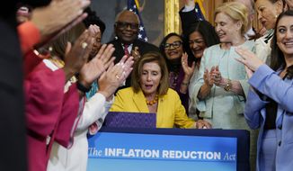 House Speaker Nancy Pelosi of Calif., surrounded by House Democrats, signs the Inflation Reduction Act of 2022 during a bill enrollment ceremony on Capitol Hill in Washington, Friday, Aug. 12, 2022. (AP Photo/Mariam Zuhaib)