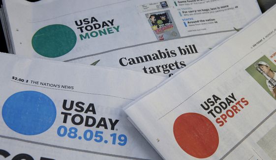 FILE - Sections of a USA Today newspaper lie on display, Aug. 5, 2019, in Norwood, Mass. On Friday, Aug. 12, 2022, newspaper publisher Gannett Co., confirmed that it’s laying off some of its newsroom staff, part of a cost-cutting effort to lower its expenses as revenue crumbles amid a downturn in ad sales and customer subscriptions. (AP Photo/Steven Senne, File)