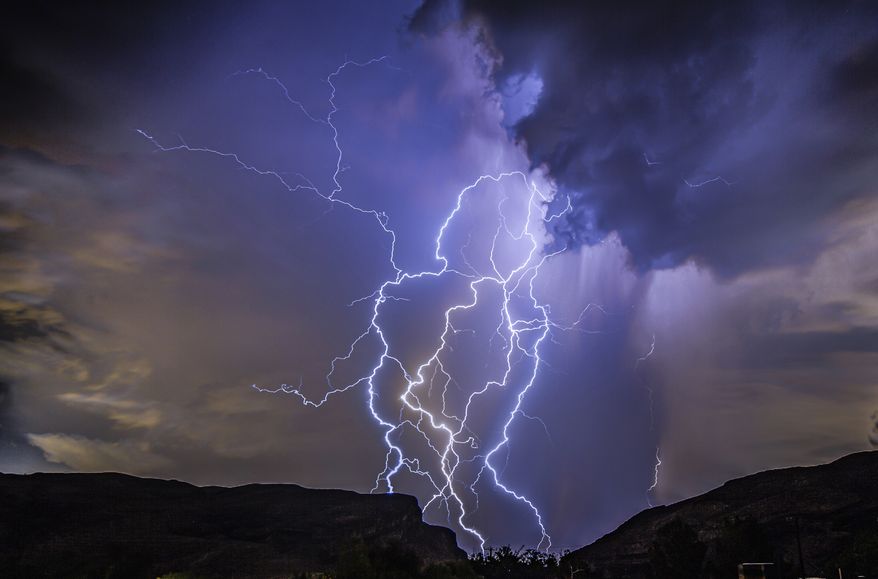 In this photo provided by Dakota Snider, a thunderstorm is seen from Highway 159 over Las Vegas on Thursday, Aug. 11, 2022. A summer monsoon thunderstorm season unseen in Las Vegas in the last 10 years brought lightning and heavy rain to some areas late Thursday, and ceiling leaks that soaked playing cards and gambling at some Strip casinos. No injuries were reported, and damage estimates were not immediately provided as Friday dawned sunny and clear. (Dakota Snider via AP)
