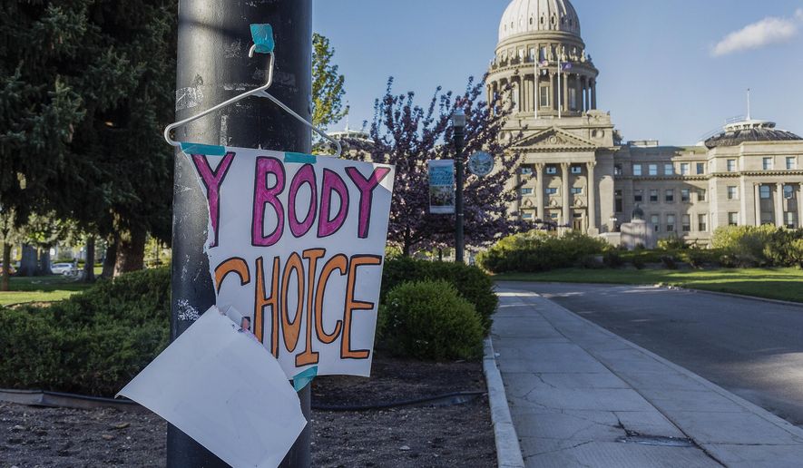 A sign reading &amp;quot;My body, my Choice,&amp;quot; is taped to a hanger taped to a streetlight in front of the Idaho State Capitol Building on May 3, 2022. The Idaho Supreme Court ruled on Friday, Aug. 12, that the state&#x27;s strict abortion bans will be allowed to take effect while legal challenges over the laws play out in court. (Sarah A. Miller/Idaho Statesman via AP) **FILE**
