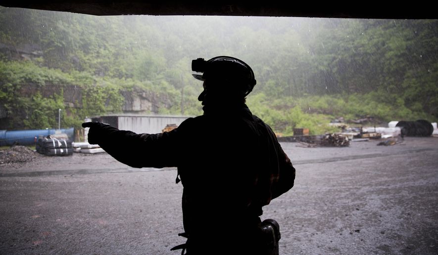 Coal miner Scott Tiller takes shelter from the rain after coming out of an underground mine at the end of a shift in Welch, W.Va., May 12, 2016. The sprawling economic package passed by the U.S. Senate this week has a certain West Virginia flavor. The bill could be read largely as an effort to help West Virginia look to the future without turning away entirely from its roots. (AP Photo/David Goldman, File)