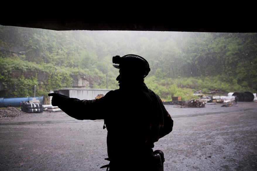 Coal miner Scott Tiller takes shelter from the rain after coming out of an underground mine at the end of a shift in Welch, W.Va., May 12, 2016. The sprawling economic package passed by the U.S. Senate this week has a certain West Virginia flavor. The bill could be read largely as an effort to help West Virginia look to the future without turning away entirely from its roots. (AP Photo/David Goldman, File)