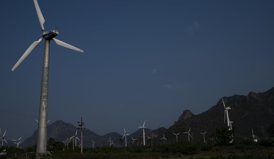 FILE - Wind turbines at one of Asia's largest wind farms work with the backdrop of Western Ghats at Aralvaimozhi, southern Tamil Nadu state, India, April 2, 2021. India will miss its renewable energy targets for the end of the year, with experts saying “multiple challenges” including a lack of financial help and taxes on imported components are stalling the clean energy industry. (AP Photo/R S Iyer, File)