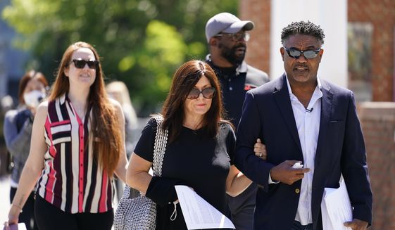 FILE - Former NFL players Ken Jenkins, right, and Clarence Vaughn III, center right, along with their wives, Amy Lewis, center, and Brooke Vaughn, left, carry tens of thousands of petitions demanding equal treatment for everyone involved in the settlement of concussion claims against the NFL, to the federal courthouse in Philadelphia on May 14, 2021. Hundreds of Black NFL retirees denied payouts in the $1 billion concussion settlement now qualify for awards after their tests were rescored to eliminate racial bias. Changes to the settlement made last year are meant to make the tests race-blind. (AP Photo/Matt Rourke, File)