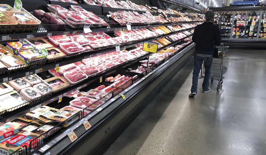 In this May 10, 2020 file photo, a shopper pushes his cart past a display of packaged meat in a grocery store in southeast Denver. Prices at the wholesale level fell from June to July, the first month-to-month drop in more than two years and a sign that some of the U.S. economy&#39;s inflationary pressures cooled last month. Thursday’s report from the Labor Department showed that the producer price index — which measures inflation before it reaches consumers — declined 0.5% in July. (AP Photo/David Zalubowski, File)
