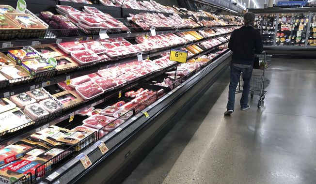 In this May 10, 2020 file photo, a shopper pushes his cart past a display of packaged meat in a grocery store in southeast Denver. Prices at the wholesale level fell from June to July, the first month-to-month drop in more than two years and a sign that some of the U.S. economy&#x27;s inflationary pressures cooled last month. Thursday’s report from the Labor Department showed that the producer price index — which measures inflation before it reaches consumers — declined 0.5% in July. (AP Photo/David Zalubowski, File)