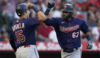 Minnesota Twins&#39; Gilberto Celestino (67) celebrates with Gio Urshela (15) after hitting a home run during the second inning of a baseball game in Anaheim, Calif., Friday, Aug. 12, 2022. Urshela also scored. (AP Photo/Ashley Landis)