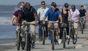 President Joe Biden rides a bicycle with others along the beach at Kiawah Island, S.C., Sunday, Aug. 14, 2022. Biden is in Kiawah Island with his family on vacation. (AP Photo/Manuel Balce Ceneta)