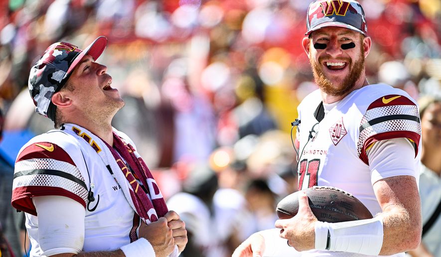 Washington Commanders quarterbacks Carson Wentz (11) and Taylor Heinicke (4) during a lighthearted moment in the preseason game against the Carolina Panthers at FedEx Field, Landover, MD, August 13, 2022. (Photo by Brian Murphy)