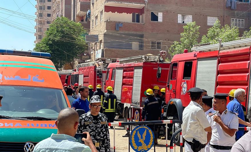 Emergency personnel work at the site of a fire at the Abu Sefein church that has killed over 40 people and injured at least 14 others, in the densely populated neighborhood of Imbaba, Cairo Egypt, Sunday, Aug. 14, 2022. The church said the fire broke out while a service was underway. The cause of the blaze was not immediately known but a Police said an initial investigation blamed an electrical short-circuit. (AP Photo/Mohamed Salah)