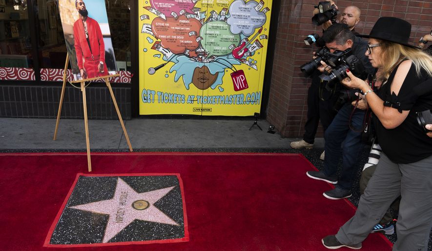 Nipsey Hussle is honored posthumously with a star on the Hollywood Walk of Fame in the category of Recording on Monday, Aug. 15, 2022, in Los Angeles. Ermias "Nipsey Hussle" Asghedom, pictured at left, was a recording artist, activist and entrepreneur. (AP Photo/Damian Dovarganes)