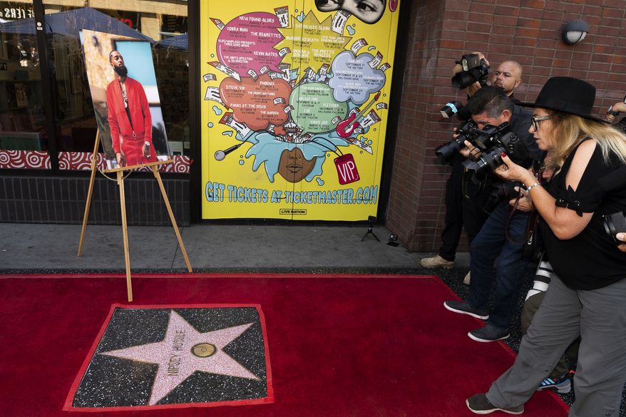 Nipsey Hussle is honored posthumously with a star on the Hollywood Walk of Fame in the category of Recording on Monday, Aug. 15, 2022, in Los Angeles. Ermias "Nipsey Hussle" Asghedom, pictured at left, was a recording artist, activist and entrepreneur. (AP Photo/Damian Dovarganes)