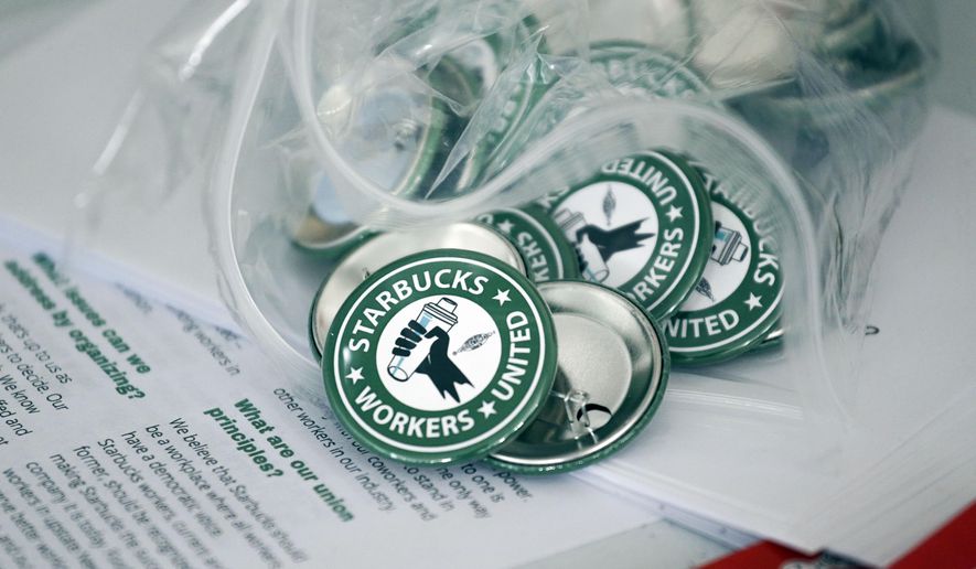 Pro-union pins sit on a table during a watch party for Starbucks&#x27; employees union election, Dec. 9, 2021, in Buffalo, N.Y. Starbucks is asking the National Labor Relations Board to temporarily suspend all union elections at its U.S. stores in response to allegations of improper coordination between regional NLRB officials and the union. (AP Photo/Joshua Bessex, File)
