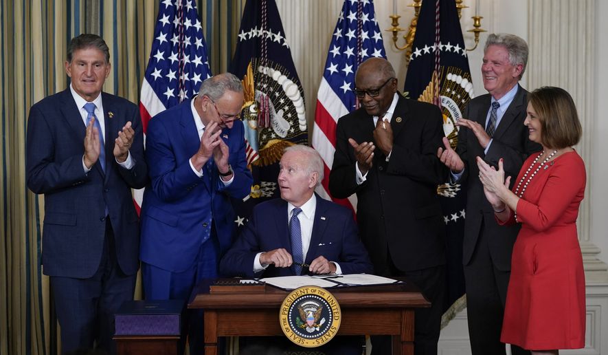 President Joe Biden signs the Democrats&#x27; landmark climate change and health care bill in the State Dining Room of the White House in Washington, Tuesday, Aug. 16, 2022, as from left, Sen. Joe Manchin, D-W.Va., Senate Majority Leader Chuck Schumer of N.Y., House Majority Whip Rep. James Clyburn, D-S.C., Rep. Frank Pallone, D-N.J., and Rep. Kathy Castor, D-Fla., watch. (AP Photo/Susan Walsh) ** FILE **