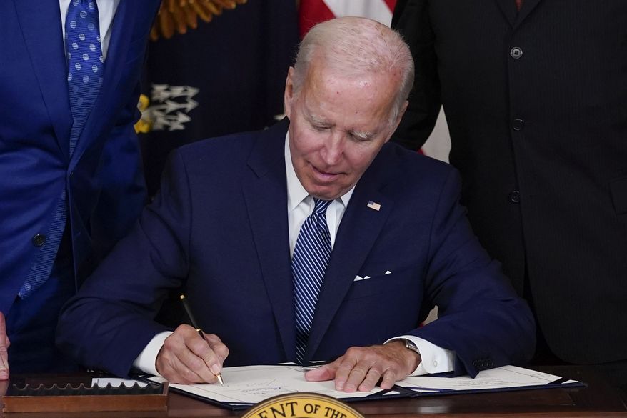 President Joe Biden signs the Democrats&#39; landmark climate change and health care bill in the State Dining Room of the White House in Washington, Tuesday, Aug. 16, 2022. (AP Photo/Susan Walsh)