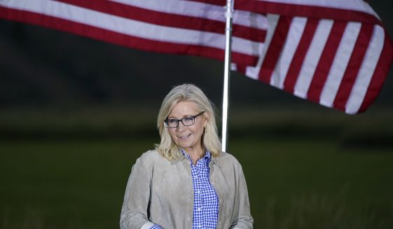 Rep. Liz Cheney, R-Wyo., stands by flags as she waits to speak, Tuesday, Aug. 16, 2022, at an Election Day gathering at Mead Ranch in Jackson, Wyo. Cheney lost to Republican challenger Harriet Hageman in the primary. (AP Photo/Jae C. Hong)