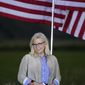 Rep. Liz Cheney, R-Wyo., stands by flags as she waits to speak, Tuesday, Aug. 16, 2022, at an Election Day gathering at Mead Ranch in Jackson, Wyo. Cheney lost to Republican challenger Harriet Hageman in the primary. (AP Photo/Jae C. Hong)