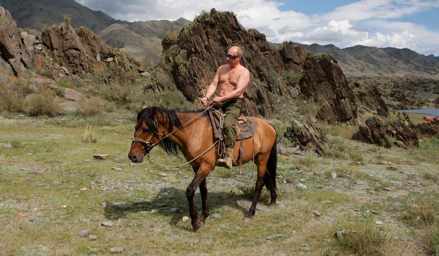 FILE - Then Russian Prime Minister Vladimir Putin rides a horse while traveling in the mountains of the Siberian Tyva region (also referred to as Tuva), Russia, Aug. 3, 2009. Putin has shot back at Western leaders who mocked his athletic exploits, saying they would look þÄúdisgustingþÄù if they tried to emulate his bare-torso appearances. Putin made the comment during a visit to Turkmenistan early Thursday, June 30, 2022 when asked about Western leaders joking about him at the G-7 summit. (Alexei Druzhinin/Pool Photo via AP, file)