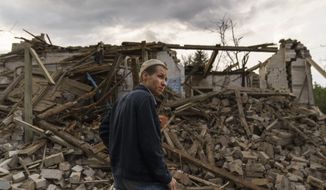 A resident looks at damaged homes from a rocket attack early this morning, Tuesday, Aug. 16, 2022, in Kramatorsk, eastern Ukraine, as Russian shelling continued to hit towns and villages in Donetsk province, regional officials said. (AP Photo/David Goldman)