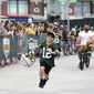 Green Bay Packers tight end Josiah Deguara, third from right, rides a young fan&#39;s bike as the fan takes off running with Deguara&#39;s helmet during the team&#39;s NFL football training camp July 27, 2022, in Green Bay, Wisc. (Samantha Madar/The Post-Crescent via AP, File) **FILE**
