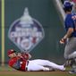 Washington Nationals first baseman Luke Voit, left, falls to the ground after he caught a popup by Chicago Cubs&#39; Patrick Wisdom (16) during the first inning of a baseball game Tuesday, Aug. 16, 2022, in Washington. (AP Photo/Nick Wass)