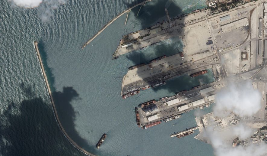 This satellite image from Planet Labs PBC shows the Sierra Leone-flagged cargo ship Razoni, center bottom with four white cranes on its red deck, at port in Tartus, Syria, Monday, Aug. 15, 2022. The first shipment of grain to leave Ukraine under a wartime deal has ended up in Syria, even as that country remains a close ally of Moscow, satellite images analyzed Tuesday by The Associated Press show. (Planet Labs PBC via AP)