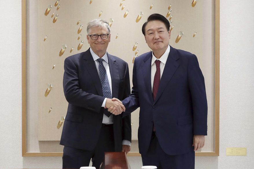 South Korean President Yoon Suk Yeol, right, shakes hands with Bill Gates before a meeting at the presidential office in Seoul, South Korea, Tuesday, Aug. 16, 2022. Gates on Tuesday called for South Korea to further step up in international efforts to prevent infectious diseases like COVID-19 as he stressed the need for the world to be better prepared for the next pandemic. (Ahn Jung-won/Yonhap via AP)