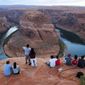 Visitors view the dramatic bend in the Colorado River at the popular Horseshoe Bend in Glen Canyon National Recreation Area, in Page, Ariz., on Sept. 9, 2011. Federal officials on Tuesday, Aug. 16, 2022, are expected to announce water cuts that would further reduce how much Colorado River water some users in the seven U.S. states reliant on the river and Mexico receive. (AP Photo/Ross D. Franklin, File)