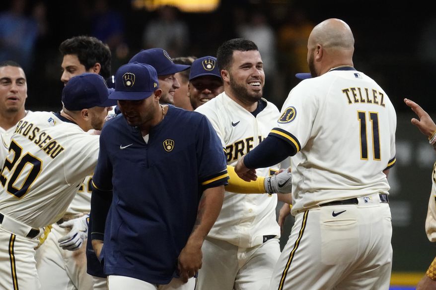 Milwaukee Brewers&#39; Victor Caratini, second from right, is congratulated by teammates after his two-run single during the 11th inning of the team&#39;s baseball game against the Los Angeles Dodgers on Tuesday, Aug. 16, 2022, in Milwaukee. The Brewers won 5-4. (AP Photo/Aaron Gash)