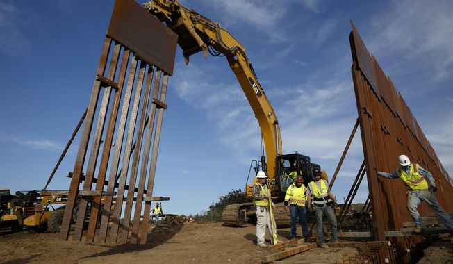 Construction crews install new border wall sections seen from Tijuana, Mexico., Jan. 9, 2019. An anti-immigration group scored a legal victory on Friday, Aug. 12, 2022, in its federal lawsuit arguing the Biden administration violated environmental law when it halted construction of the U.S. southern border wall and sought to undo other immigration policies by former President Donald Trump. (AP Photo/Gregory Bull) **FILE**