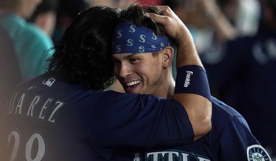 Seattle Mariners&#39; Sam Haggerty, right, is hugged by Eugenio Suarez after Haggerty scored on a single by Ty France during the sixth inning of the team&#39;s baseball game against the Los Angeles Angels on Tuesday, Aug. 16, 2022, in Anaheim, Calif. (AP Photo/Marcio Jose Sanchez)