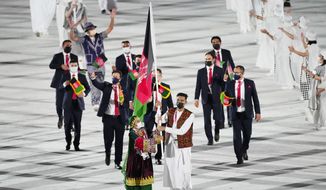 Kimia Yousofi, front left, and Farzad Mansouri, of Afghanistan, carry their country&#39;s flag during the opening ceremony in the Olympic Stadium at the 2020 Summer Olympics on July 23, 2021, in Tokyo, Japan. Afghanistan&#39;s flag bearer at the Tokyo 2020 Games and other prominent women&#39;s sports campaigners have been safely relocated to Australia following a year-long Australian Olympic Committee (AOC) project. (AP Photo/David J. Phillip, File) **FILE**