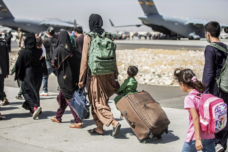In this photo provided by the U.S. Marine Corps, families walk towards their flight during ongoing evacuations at Hamid Karzai International Airport, in Kabul, Afghanistan, on Aug. 24, 2021. (Sgt. Samuel Ruiz/U.S. Marine Corps via AP) **FILE**