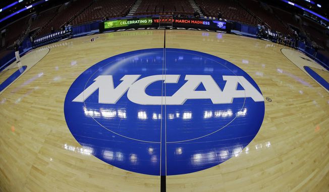 In this March 21, 2013, file photo, taken with a fisheye lens, the NCAA logo is displayed on the court during the NCAA college basketball tournament in Philadelphia. NCAA officials sent a letter to its membership Thursday, AUg. 18, 2022, noting its enforcement&#x27;s staff pursuit of “potential violations” of the name, image and likeness compensation policy and emphasizing the need for schools to help investigations. (AP Photo/Matt Slocum, File) **FILE**
