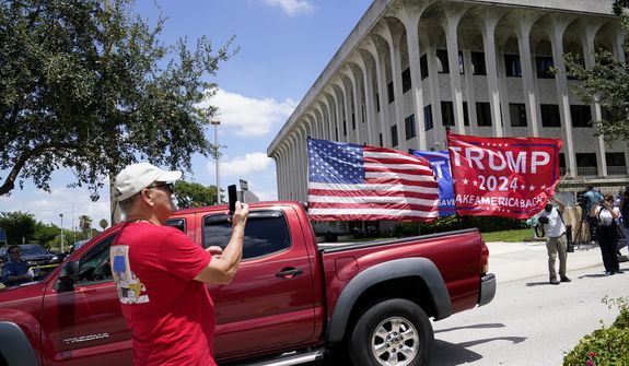 A vehicle with flags in support of Donald Trump drives outside of the Paul G. Rogers Federal Courthouse, Thursday, Aug. 18, 2022, in West Palm Beach, Fla. Attorneys for the nation&#39;s largest media companies are presenting their case before a federal magistrate judge to make public the affidavit supporting the warrant that allowed FBI agents to search former President Donald Trump&#39;s Mar-a-Lago estate in Florida. (AP Photo/Lynne Sladky)