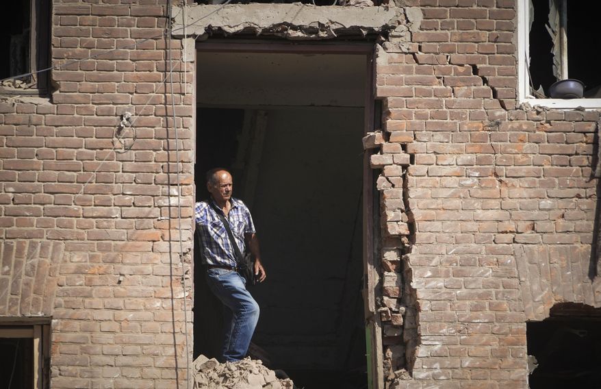 Local resident stands in a building destroyed during a missile strike in Kharkiv, Ukraine, Thursday, Aug. 18, 2022. (AP Photo/Andrii Marienko)