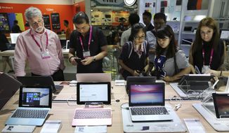 Visitors review new Asus computer products at the Computex trade show in Taipei, Taiwan, Tuesday, June 2, 2015. The U.S. government has announced talks with Taiwan, Thursday, Aug. 18, 2022, on a trade treaty in a new sign of support for the self-ruled island democracy claimed by China’s ruling Communist Party as part of its territory. (AP Photo/Wally Santana, File)