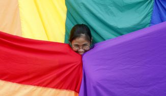 A supporter of the Philippine LGBT (Lesbians Gays Bisexual Transgender) group poses before the rainbow flag during the annual celebration of &amp;quot;Pride March&amp;quot; June 30, 2018, in Marikina city, east of Manila, Philippines. Singapore’s announcement Sunday, Aug. 22, 2022, that it would decriminalize sex between men is being hailed as a step in the right direction for LGBTQ rights in the Asia-Pacific region, a vast area of nearly 5 billion people with different laws and attitudes. (AP Photo/Bullit Marquez, File)