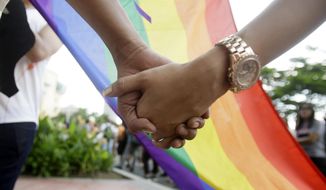 A couple holds hands as they gather for the Gay Pride rally Saturday, June 27, 2015, in Mania, Philippines. (AP Photo/Bullit Marquez, File)