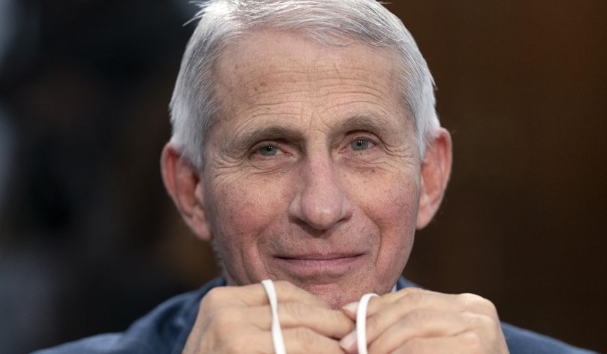 FILE - Dr. Anthony Fauci, Director of the National Institute of Allergy and Infectious Diseases, holds his face mask in his hands as he attends a House Committee on Appropriations subcommittee hearing on about the budget request for the National Institutes of Health, May 11, 2022, on Capitol Hill in Washington. Fauci, the nation's top infectious disease expert who became a household name, and the subject of partisan attacks, during the COVID-19 pandemic, announced Monday he will depart the federal government in December after more than 5 decades of service. (AP Photo/Jacquelyn Martin, File)