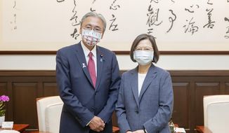 In this photo released by the Taiwan Presidential Office, Taiwan&#39;s President Tsai Ing-wen, right, poses for photos with Keiji Furuya, an ultra-conservative who heads a Japan-Taiwan parliamentarians group, in Taipei, Taiwan on Tuesday, Aug. 23, 2022. Taiwan&#39;s president invoked an armed conflict from 1958 as an example of the island&#39;s resolve to defend itself while she met Tuesday with more foreign visitors amid the highest tensions with China in decades. (Taiwan Presidential Office via AP)