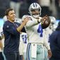 Dallas Cowboys quarterback Dak Prescott (4) warms up with offensive coordinator Kellen Moore, left, before an NFL football game against the Los Angeles Chargers Wednesday, Aug. 24, 2022, in Inglewood, Calif. (AP Photo/Ashley Landis)