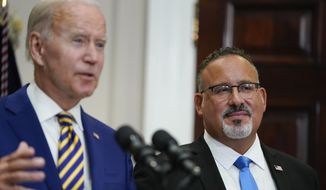 Education Secretary Miguel Cardona listens as President Joe Biden speaks about student loan debt forgiveness in the Roosevelt Room of the White House, Wednesday, Aug. 24, 2022, in Washington. (AP Photo/Evan Vucci) **FILE**