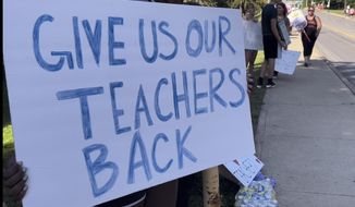 Teachers march on sidewalks outside Whetstone High School in Columbus, Ohio, as part of a district-wide teacher&#39;s strike on Wednesday, Aug. 24, 2022. A strike by teachers in Ohio&#39;s largest school district entered its third day Wednesday — the first day of school for some 47,000 students, with some of those students and their parents rallying to their sides.  (AP Photo/Samantha Hendrickson)