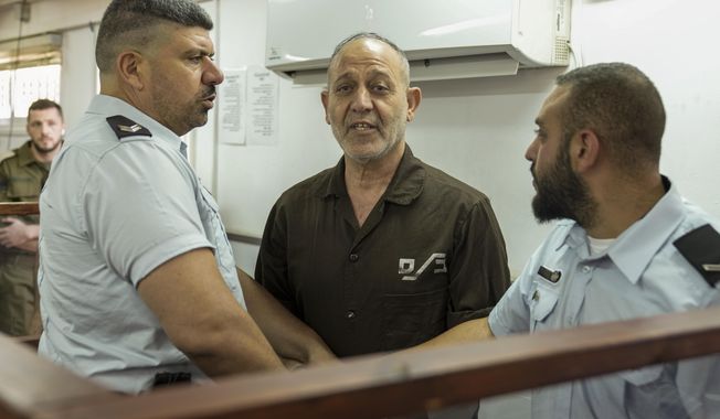 FILE - Palestinian Bassam al-Saadi, center, a senior Islamic Jihad militant, appears in a courtroom for a hearing, at the Israeli Ofer military base near the West Bank city of Ramallah, Sunday, Aug. 21, 2022. The Israeli military filed terror charges Thursday, Aug. 25, 2022 against the Senior Islamic Jihad commander.(AP Photo/Mahmoud Illean, File)