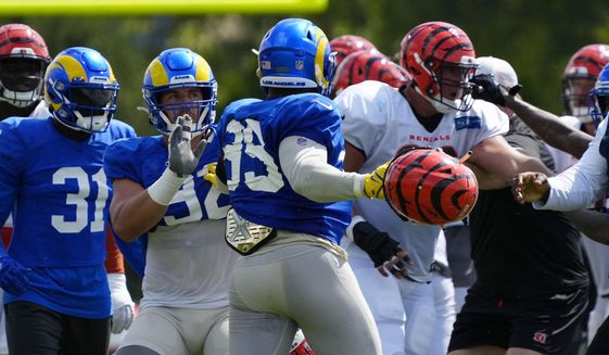 Los Angeles Rams defensive tackle Jonah Williams (92) attempts to hold back Rams defensive tackle Aaron Donald (99) as a third scuffle escalates into a brawl during a joint preseason NFL football camp practice between the Cincinnati Bengals and the Rams in Cincinnati, Thursday, Aug. 25, 2022. Practice was ended early after the third scuffle turned into a broader fight between players on both teams. (Sam Greene/The Cincinnati Enquirer via AP) ) **FILE**