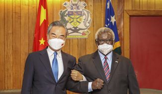 In this photo released by Xinhua News Agency, Solomon Islands Prime Minister Manasseh Sogavare, right, locks arms with visiting Chinese Foreign Minister Wang Yi in Honiara, Solomon Islands on May 26, 2022. A U.S. coast guard cutter conducting patrols as part of an international mission to prevent illegal fishing was recently unable to get clearance for a scheduled port call in the Solomon Islands, according to reports, an incident that comes amid growing concerns of Chinese influence on the Pacific nation. (Xinhua via AP, File)