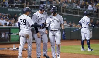 New York Yankees&#39; Jose Trevino (39), left to right, congratulates Anthony Rizzo and Gleyber Torres, after they scored against the Oakland Athletics on a double hit by Josh Donaldson during the seventh inning of a baseball game in Oakland, Calif., Thursday, Aug. 25, 2022. (AP Photo/Godofredo A. Vásquez)